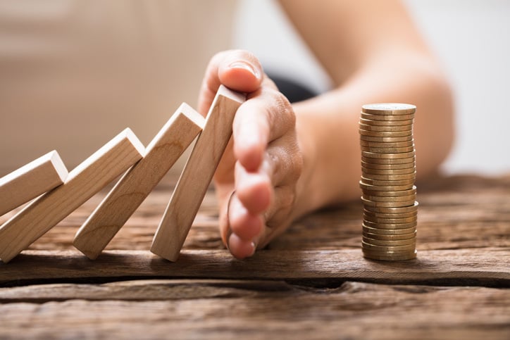 Close-up Of A Businesswomans Hand Stopping The Wooden Blocks From Falling