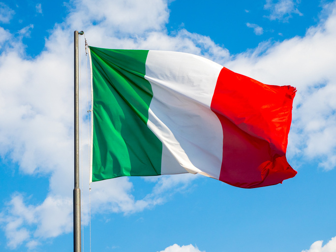 National flag of Italy waving into blue sky