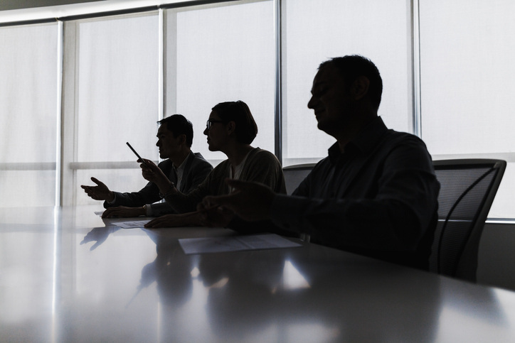 Silhouette of business people negotiating at meeting table